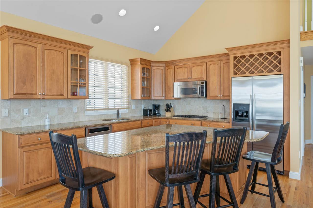 5441 Ocean Drive Avalon, NJ 08202 - Photo 14 of 26 a kitchen with stainless steel appliances granite countertop a table chairs sink and cabinets