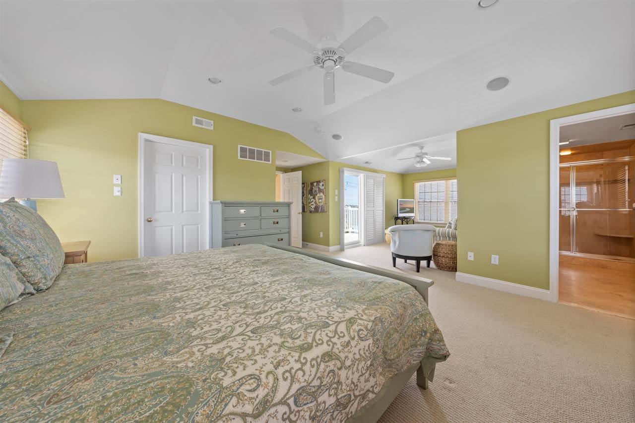 5441 Ocean Drive Avalon, NJ 08202 - Photo 21 of 26 a spacious bedroom with a bed a table and chair