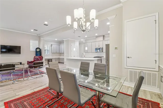 a view of a dining room with furniture a rug and wooden floor
