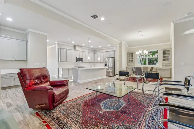 a living room with furniture wooden floor and a large window