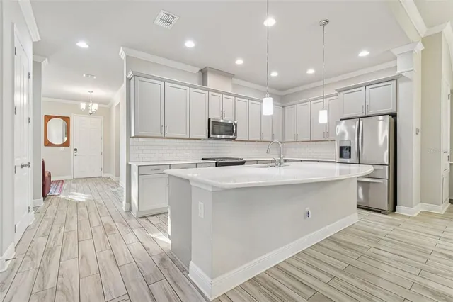 a kitchen with kitchen island a sink stainless steel appliances and cabinets