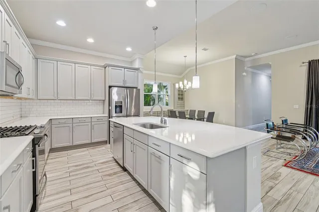 a kitchen with kitchen island granite countertop a sink stove and refrigerator