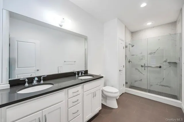 a bathroom with a double vanity sink toilet and shower