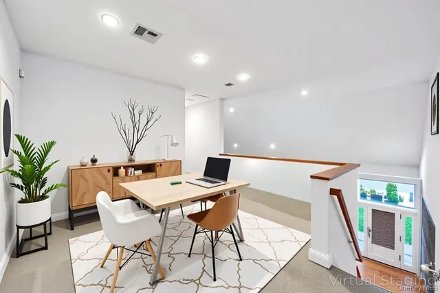 a view of a dining room with furniture and a potted plant