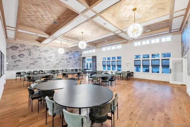 a dining room with furniture a chandelier and wooden floor