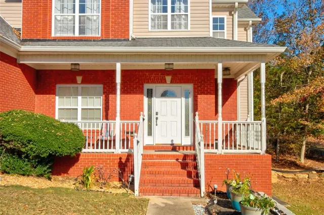 a view of a house with a small yard and wooden floor and fence