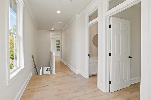 a view of a hallway with wooden floor and cabinet