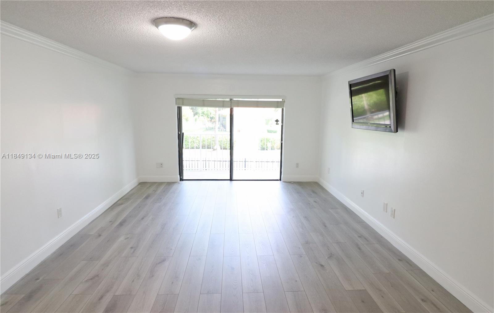 9301 Southwest 92nd Avenue, Unit A210 Miami, FL 33176 - Photo 7 of 25 an empty room with wooden floor and windows