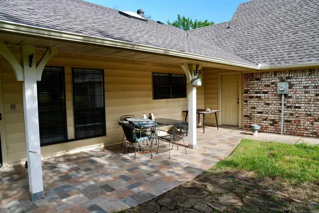 a view of a patio with table and chairs and potted plants