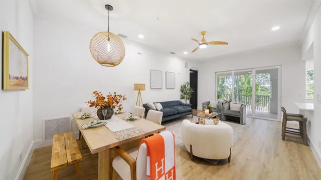 a living room with furniture a chandelier and a large window