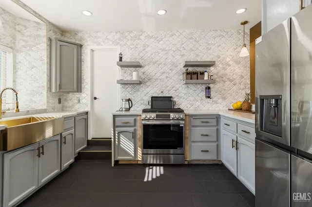 a kitchen with stainless steel appliances a stove a sink and a refrigerator