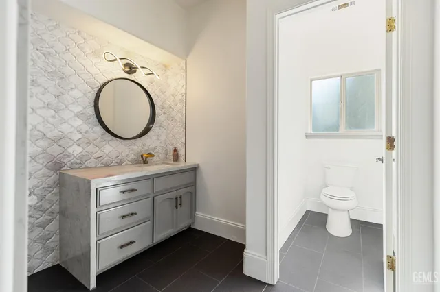 a bathroom with a toilet a sink and a mirror