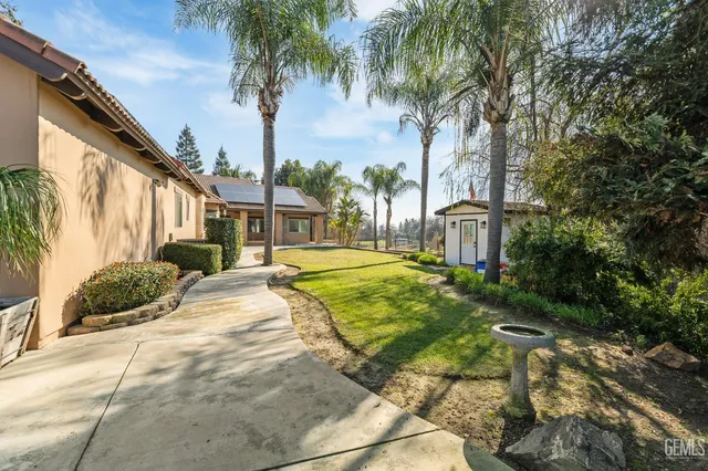 a view of a house with backyard and trees