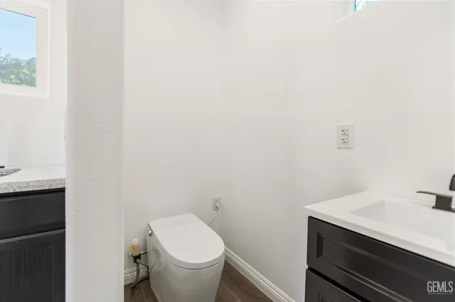 a view of an empty room with wooden floor and windows