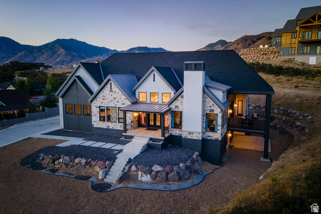 3247 South Mapleton Estates Drive Mapleton, UT 84664 - Photo 59 of 70 Back of house at dusk with stone siding, a standing seam roof, a mountain view, and a chimney
