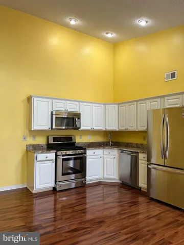 a kitchen with stainless steel appliances a stove a sink and a refrigerator