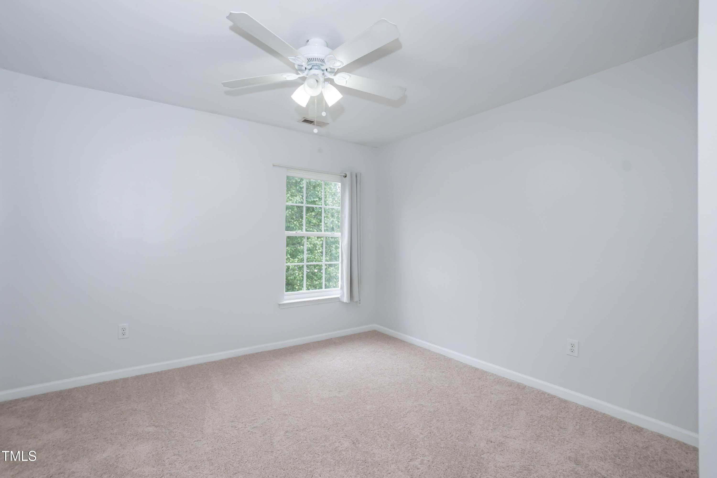 8 Kingfisher Way Durham, NC 27713 - Photo 20 of 25 an empty room with a chandelier fan and windows