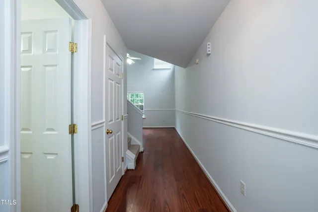 a view of a hallway with wooden floor and staircase