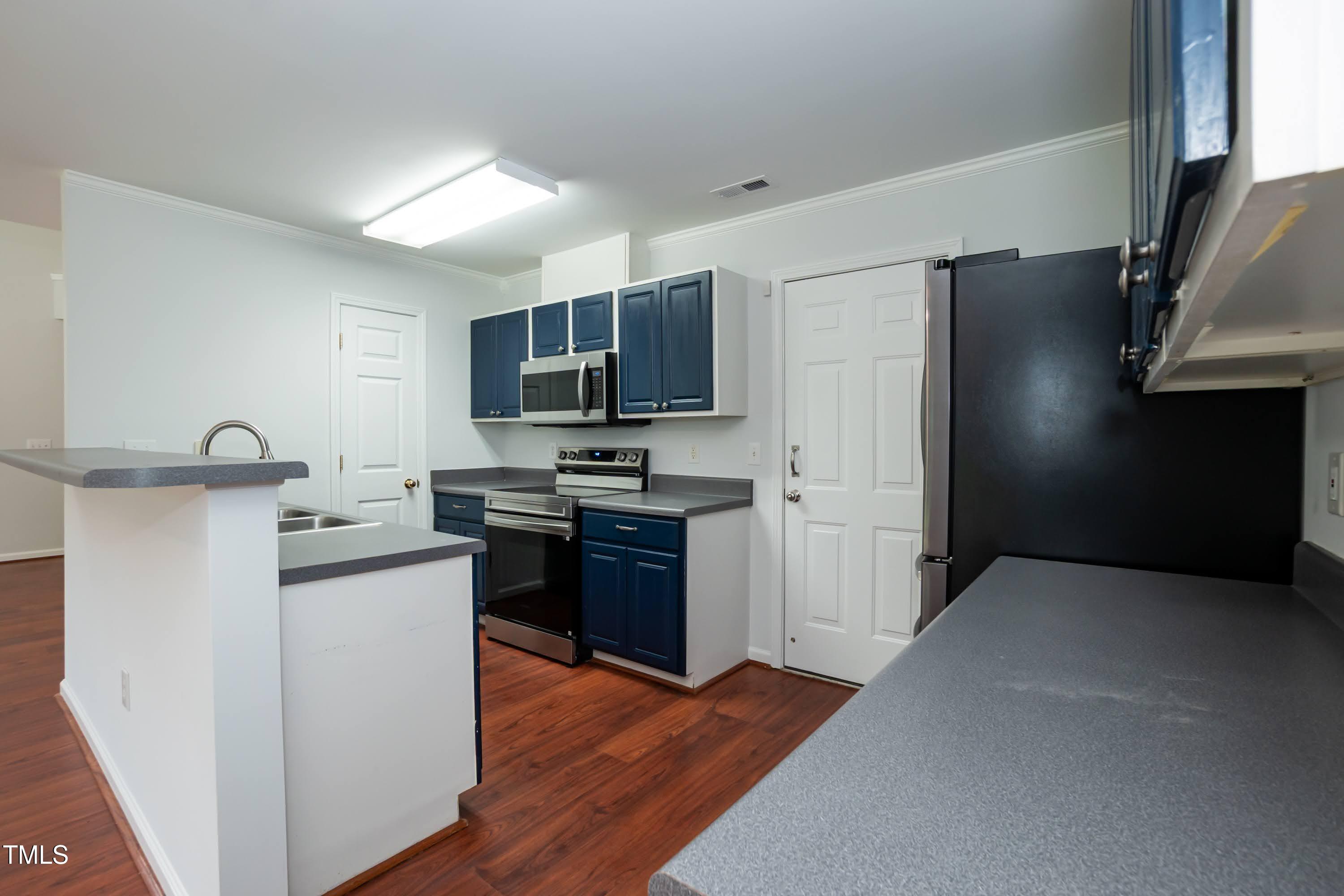 8 Kingfisher Way Durham, NC 27713 - Photo 8 of 25 a kitchen with stainless steel appliances a refrigerator stove and microwave