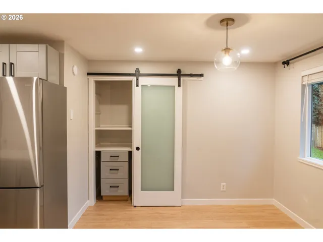 a view of a kitchen with a refrigerator and a window