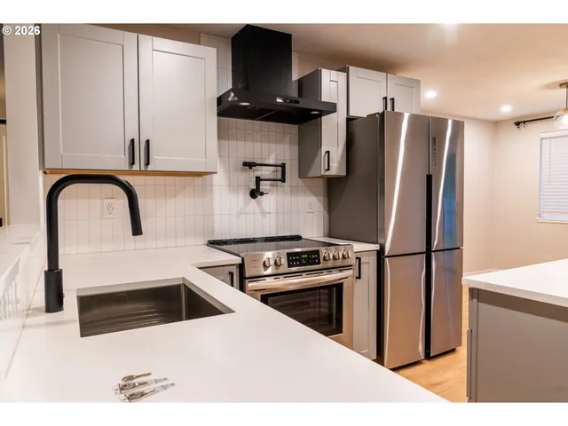 a kitchen with stainless steel appliances kitchen island a refrigerator sink and stove