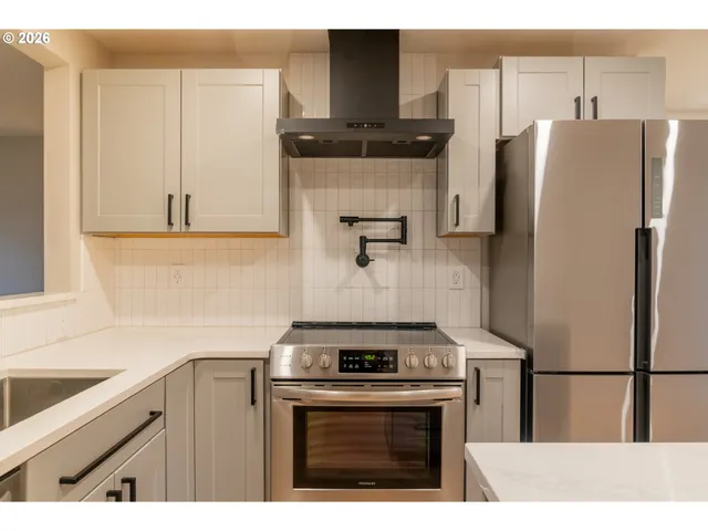 a kitchen with a refrigerator sink and cabinets