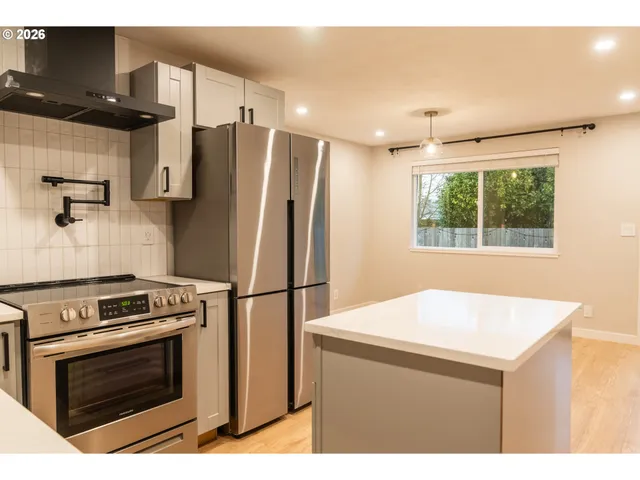 a kitchen with a refrigerator and a stove top oven