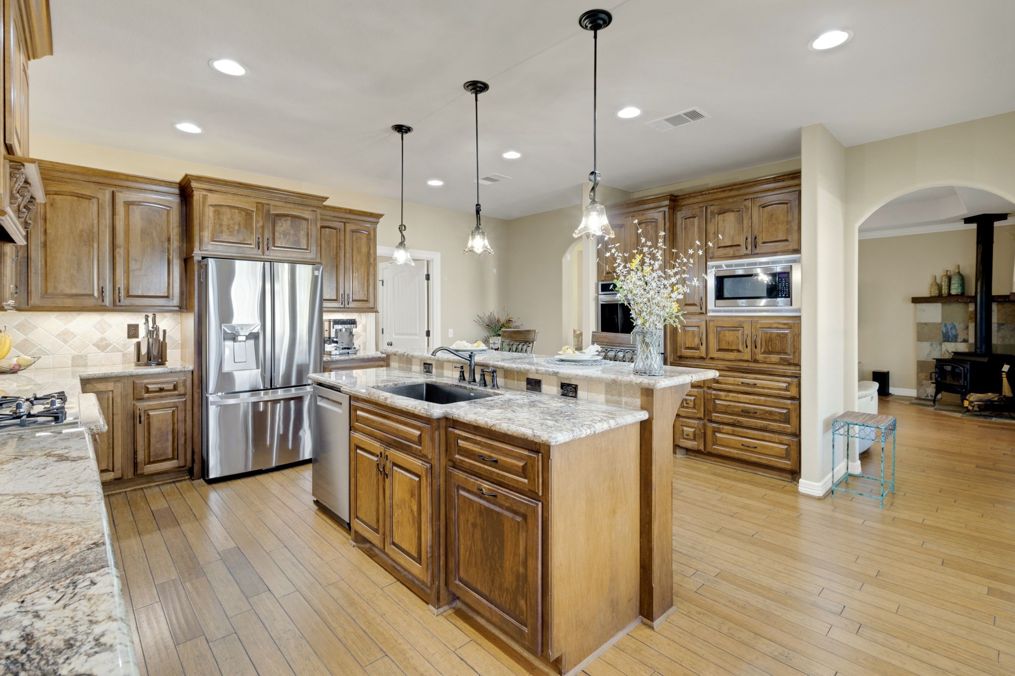 1040 Kings Way Coldspring, TX 77331 - Photo 22 of 50 a kitchen with stainless steel appliances granite countertop a refrigerator a stove and a wooden floors