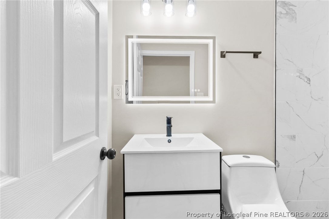 402 Gainey Road Raeford, NC 28376 - Photo 21 of 30 a bathroom with a sink a toilet and mirror