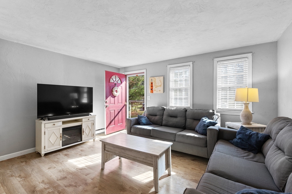 300 Falmouth Road, Unit 20D Mashpee, MA 02649 - Photo 5 of 20 a living room with furniture a flat screen tv and a window
