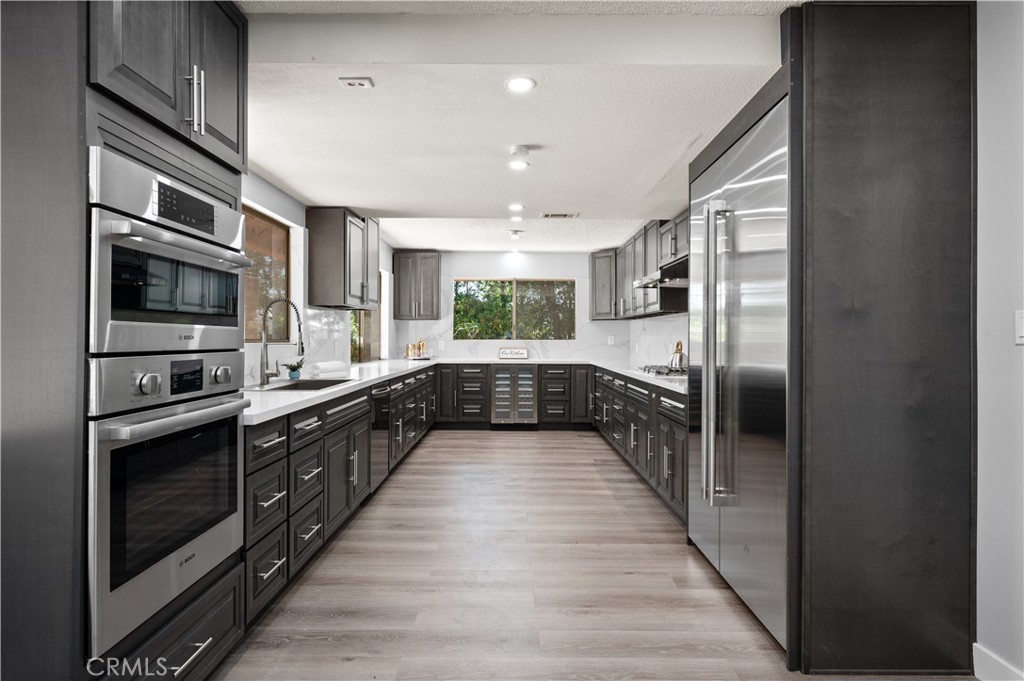 18561 Bert Road Riverside, CA 92508 - Photo 16 of 72 a large kitchen with stainless steel appliances granite countertop a large stove top oven a refrigerator and a microwave