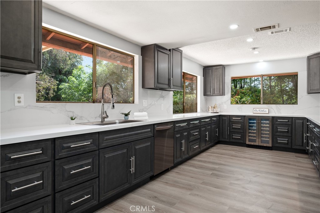 18561 Bert Road Riverside, CA 92508 - Photo 17 of 72 a kitchen with stainless steel appliances kitchen island granite countertop a large window and wooden cabinets