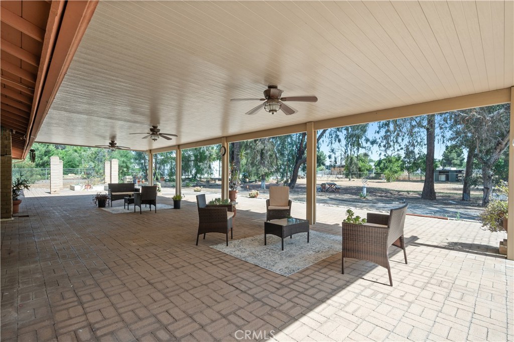 18561 Bert Road Riverside, CA 92508 - Photo 46 of 72 a view of a patio with table and chairs potted plants with floor to ceiling window
