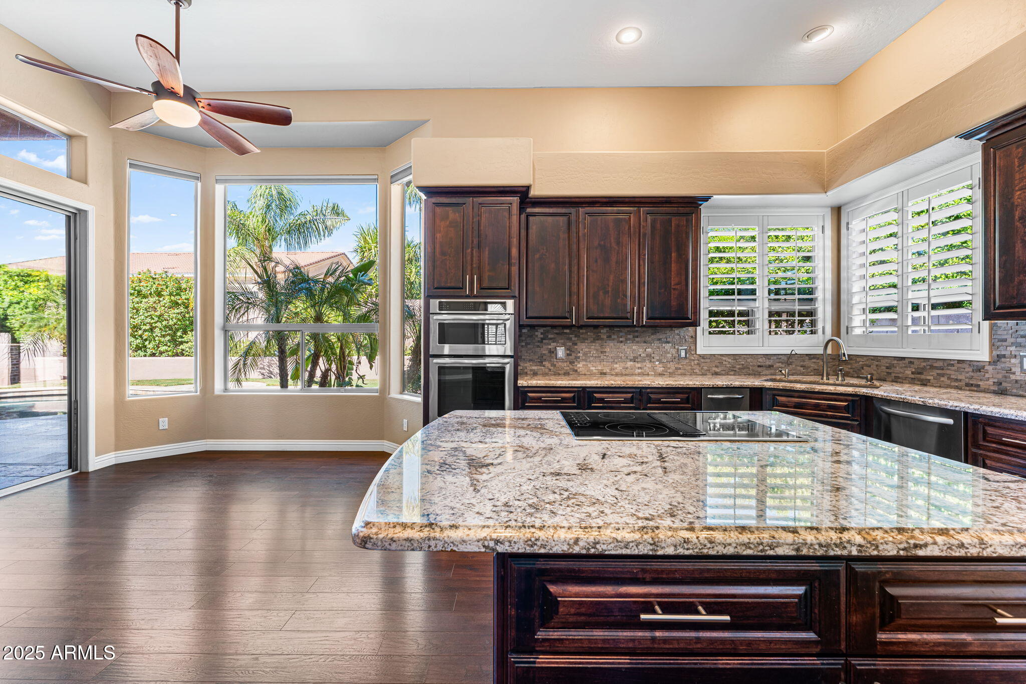 4410 East Robin Lane Phoenix, AZ 85050 - Photo 11 of 44 a kitchen with kitchen island granite countertop a stove and a wooden floor
