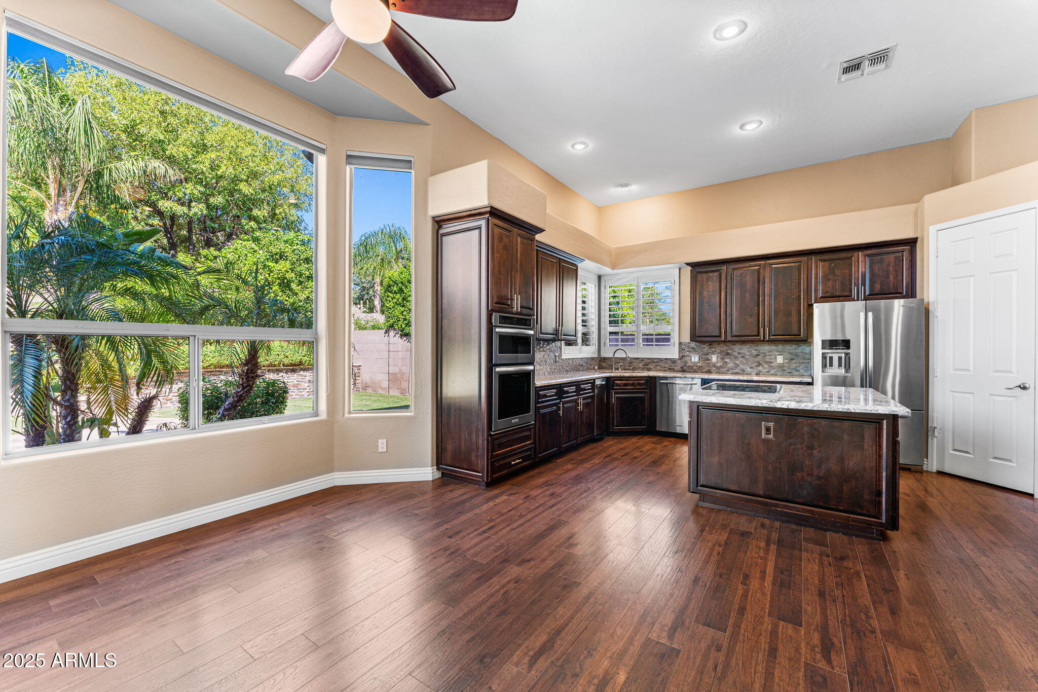 4410 East Robin Lane Phoenix, AZ 85050 - Photo 15 of 44 a large kitchen with stainless steel appliances wooden floors and wooden cabinets