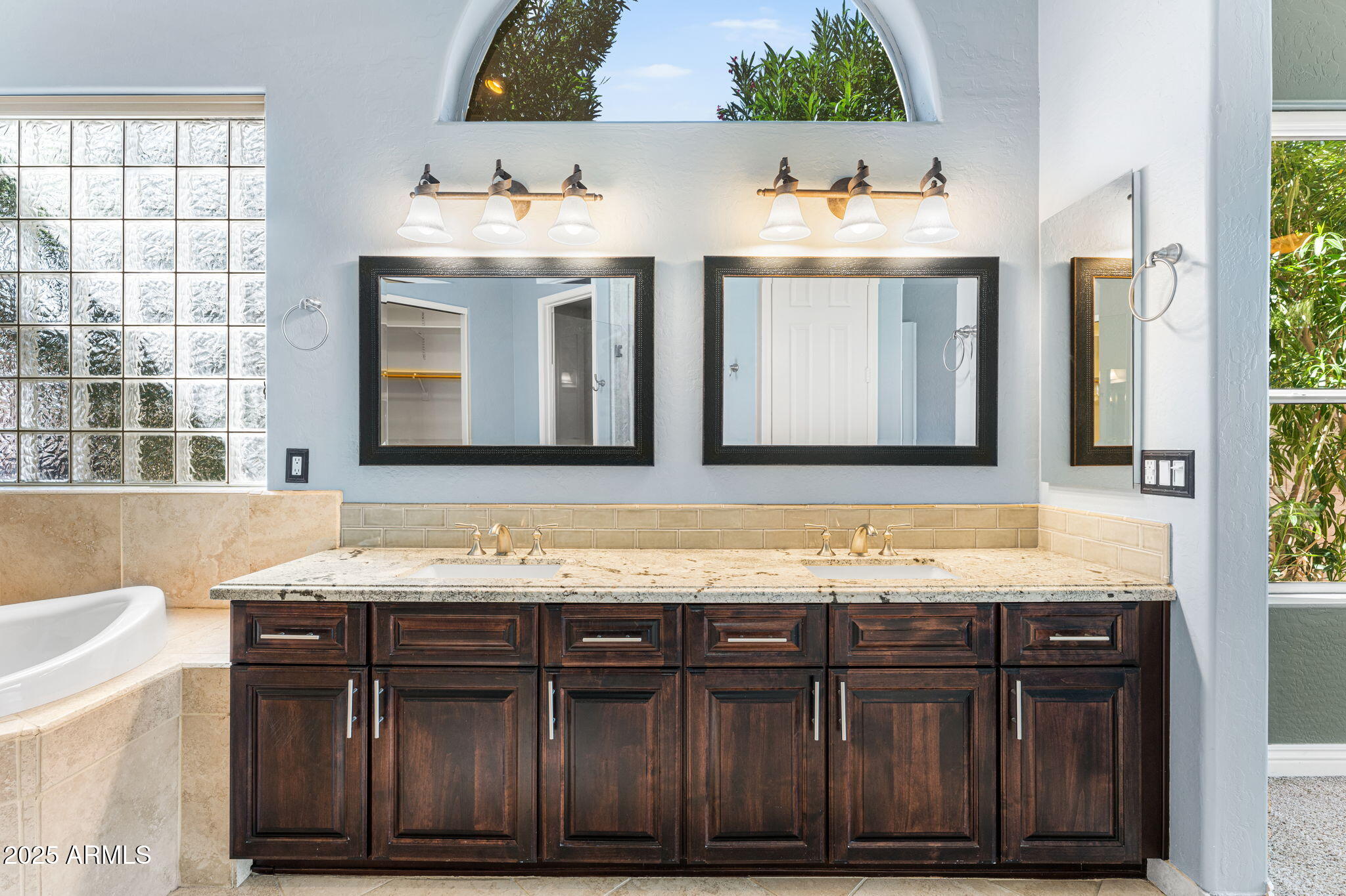 4410 East Robin Lane Phoenix, AZ 85050 - Photo 21 of 44 a bathroom with a granite countertop sink and a mirror