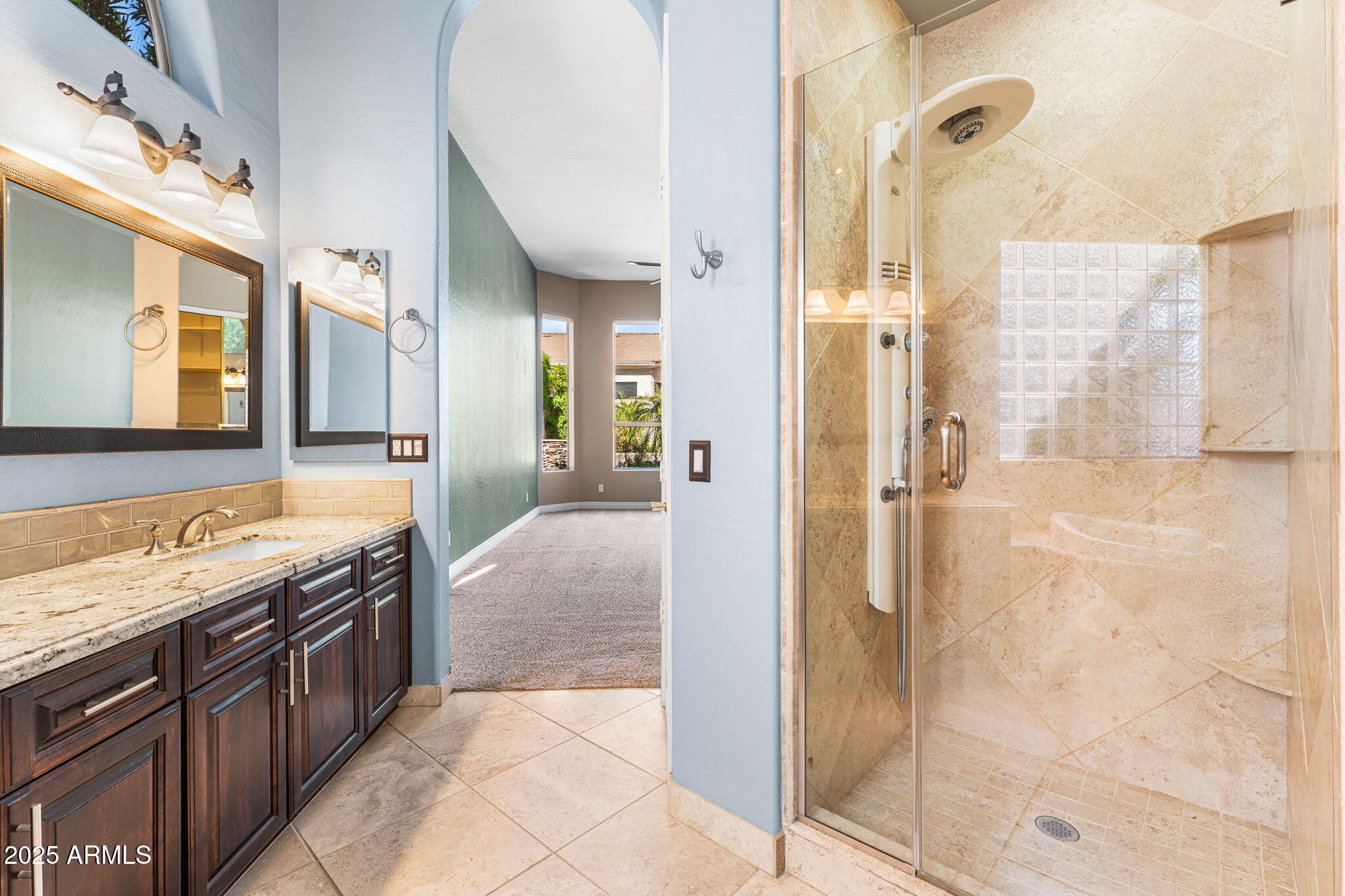 4410 East Robin Lane Phoenix, AZ 85050 - Photo 23 of 44 a spacious bathroom with a granite countertop shower a sink and a mirror