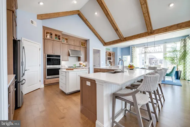 a view of a dining room with furniture a kitchen and chandelier