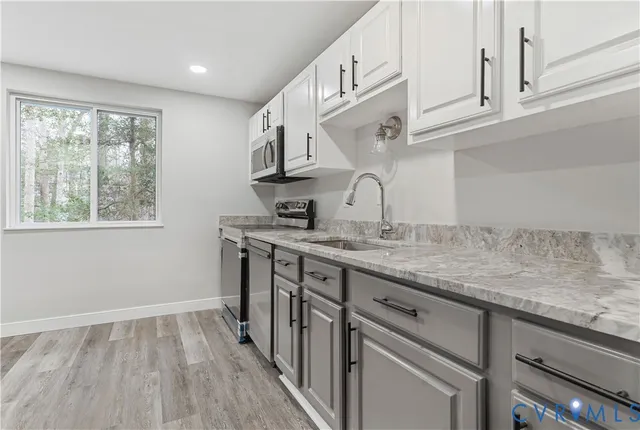 a kitchen with stainless steel appliances granite countertop a sink and cabinets