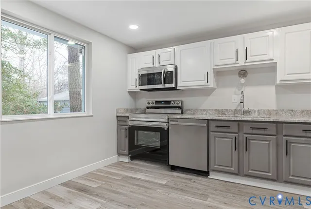 a kitchen with granite countertop a stove a sink and a microwave