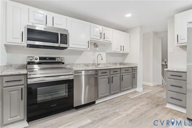 a kitchen with stainless steel appliances a stove a sink and a microwave