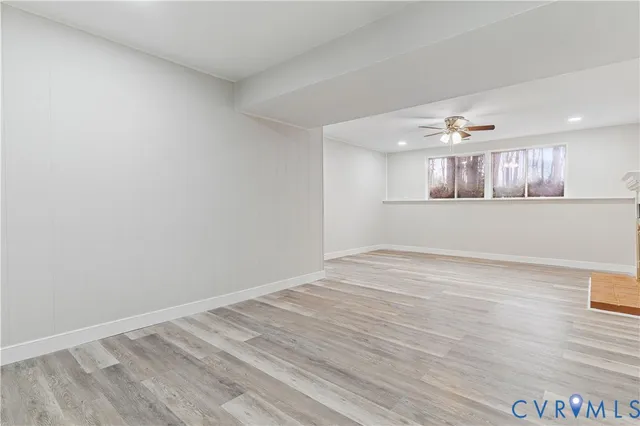 a view of empty room with wooden floor and window