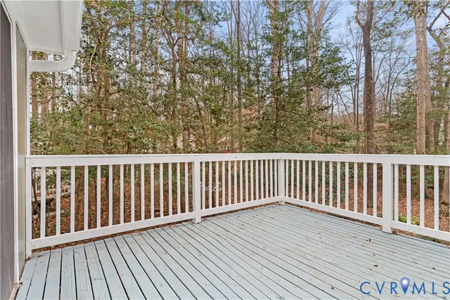 a balcony with wooden floor and trees