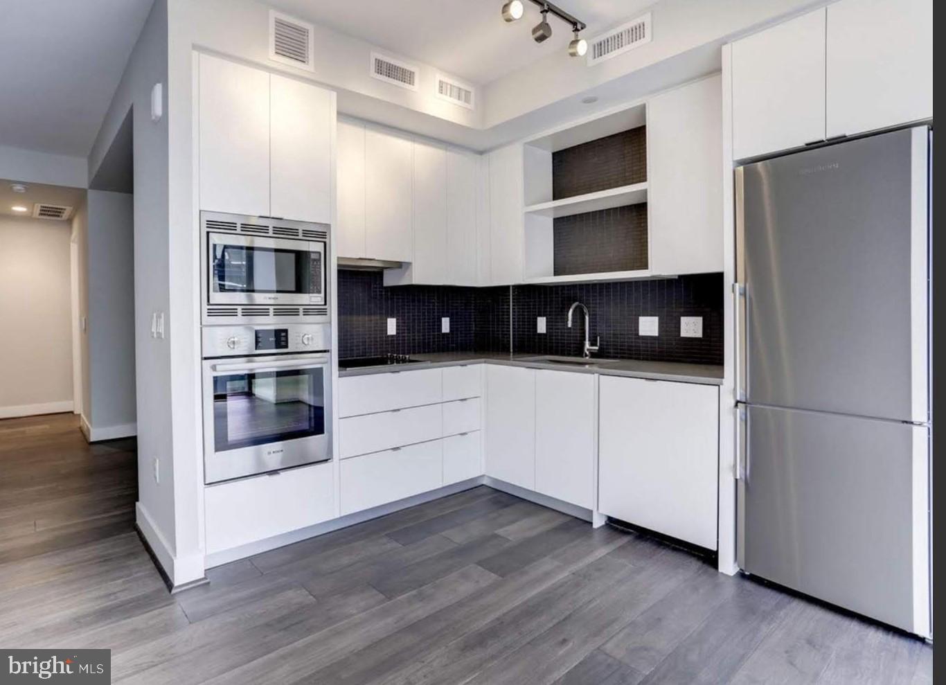 a kitchen with stainless steel appliances a refrigerator and a stove top oven
