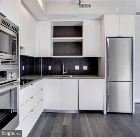 a kitchen with stainless steel appliances a refrigerator sink and cabinets