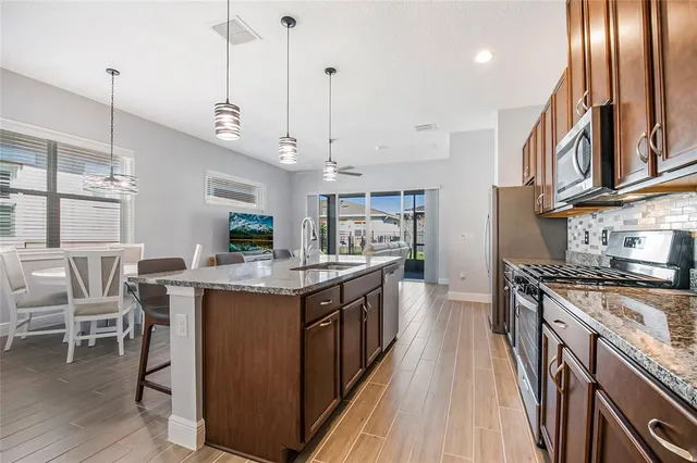 a kitchen with kitchen island granite countertop lots of counter top space and stainless steel appliances