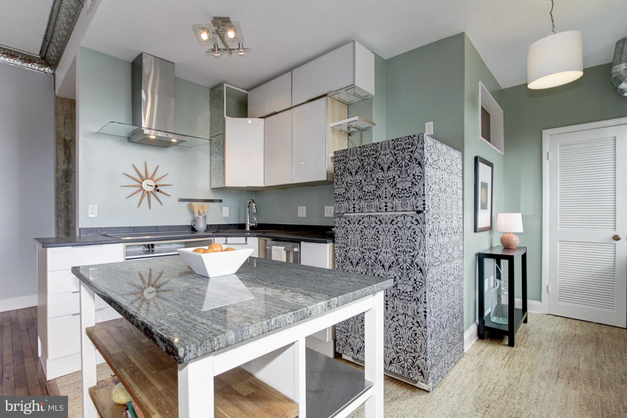 1701 16th Street Northwest, Unit 802 Washington, DC 20009 - Photo 5 of 11 a kitchen with stainless steel appliances granite countertop a kitchen island a stove and a sink