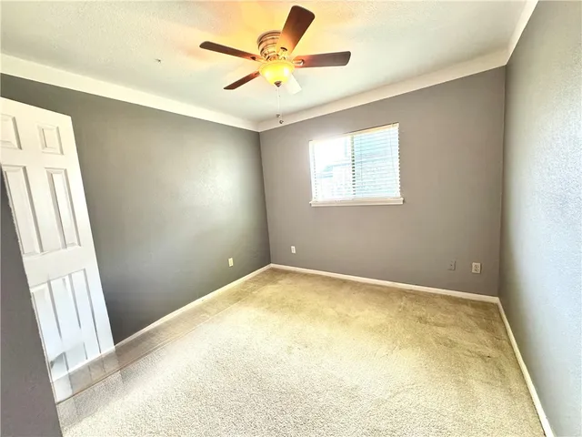 an empty room with a window and a fan