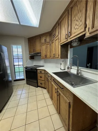 a kitchen with stainless steel appliances granite countertop a sink stove and cabinets