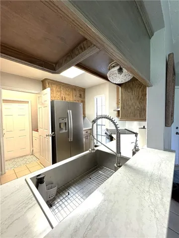 a large bedroom with a large bed a chandelier and windows